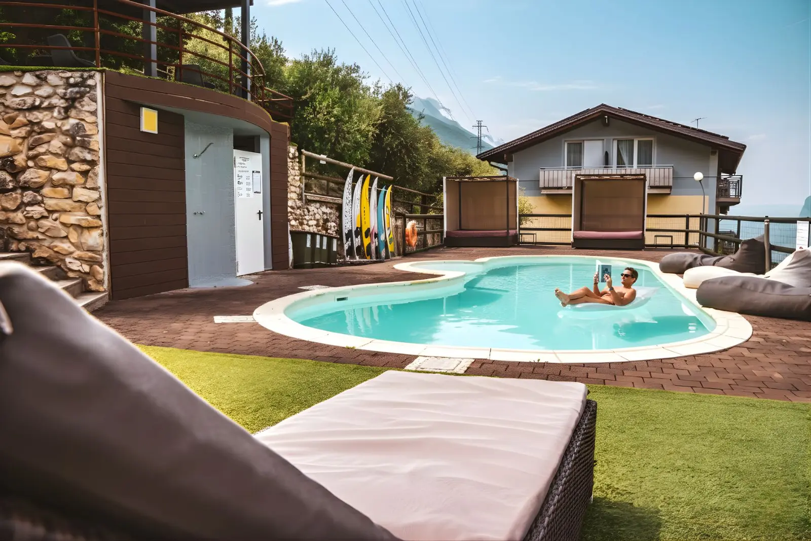 Il bordo della piscina con i lettini e il gazebo